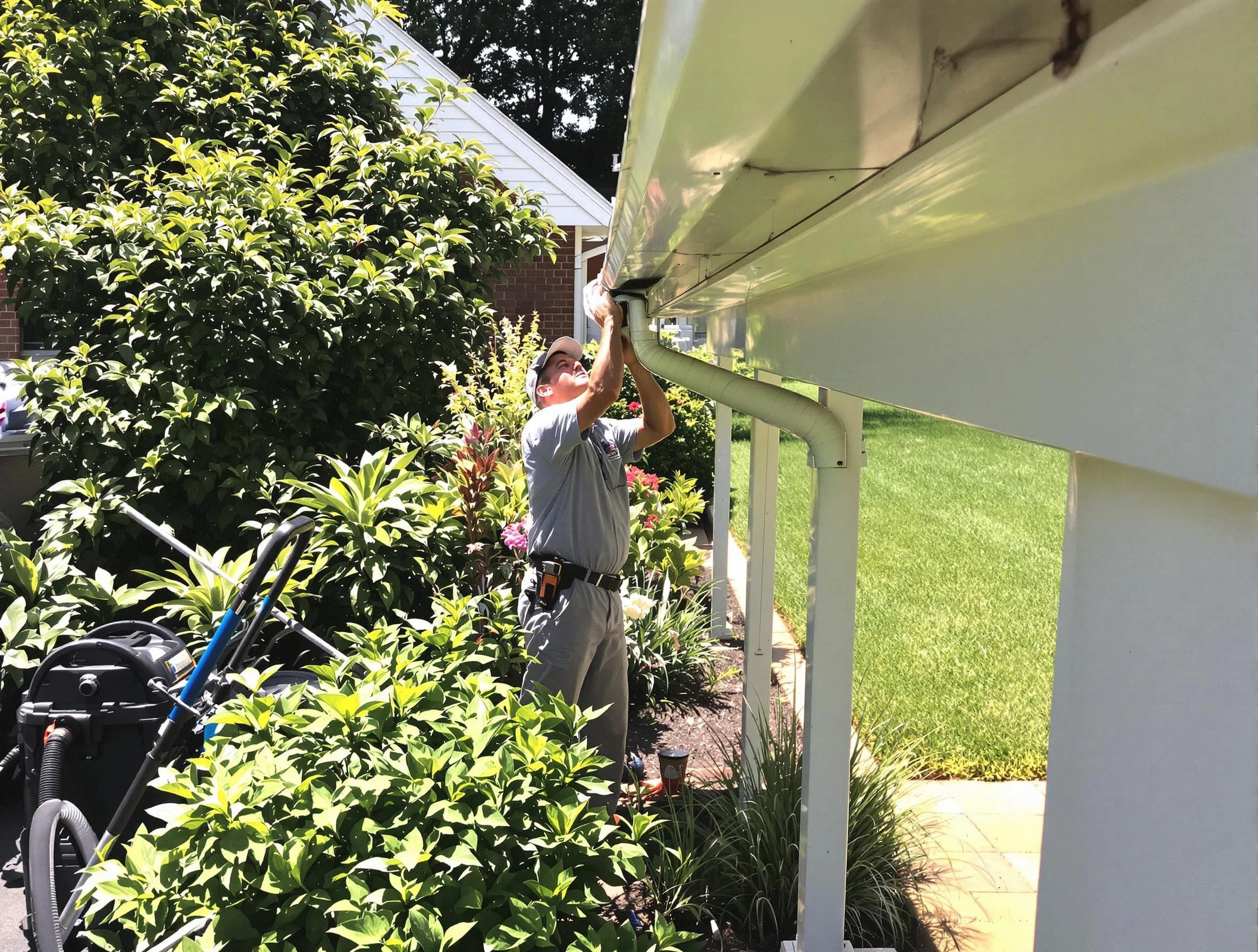 Technician flushing a blockage from a downspout in Elyria, OH